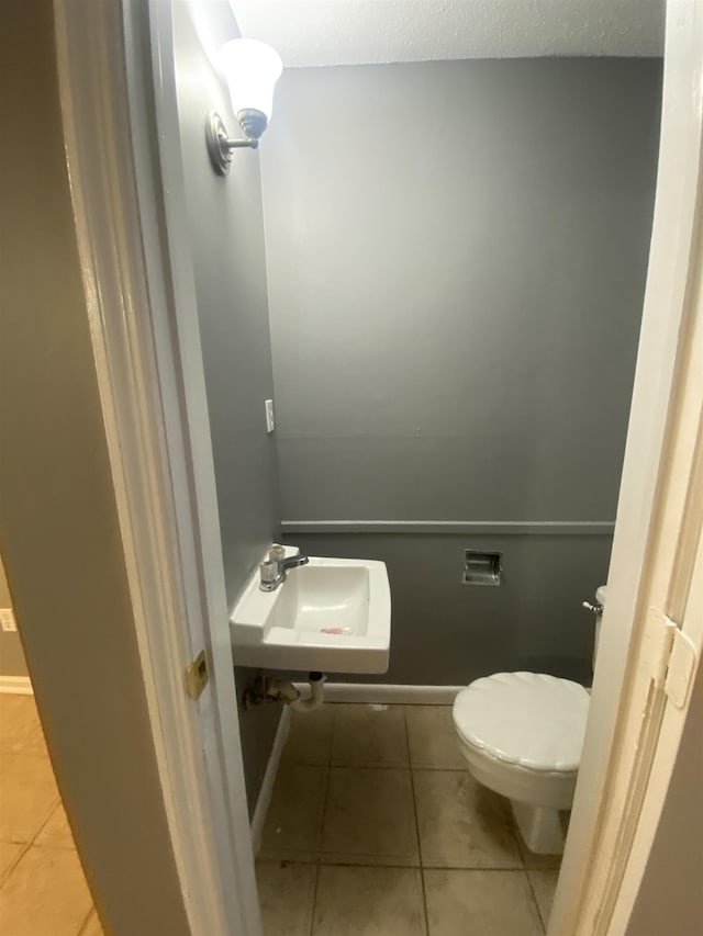 bathroom featuring sink, tile patterned floors, and toilet