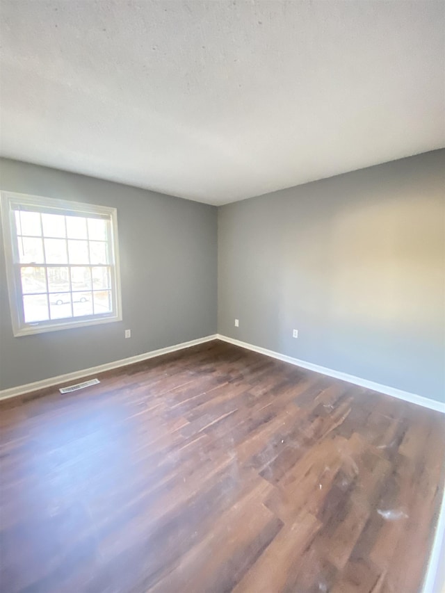 empty room with dark hardwood / wood-style flooring