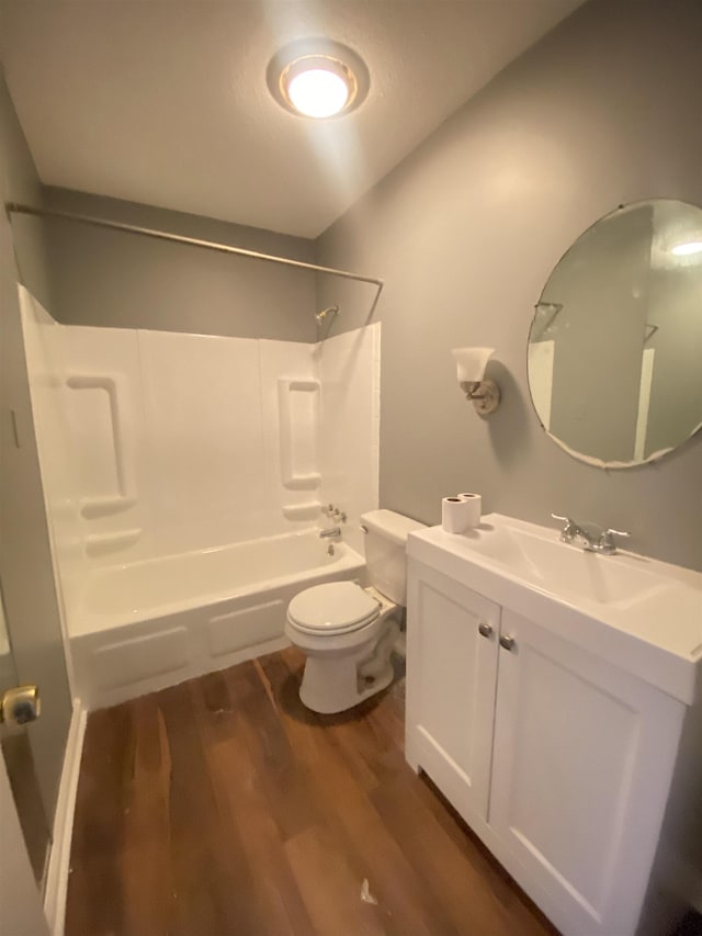 full bathroom with shower / bathing tub combination, vanity, hardwood / wood-style flooring, and toilet