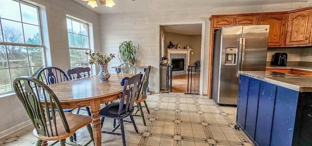 dining area with a textured ceiling and wood walls