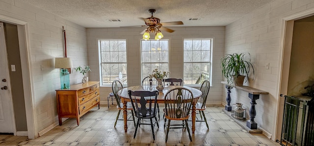 dining room featuring ceiling fan and a textured ceiling