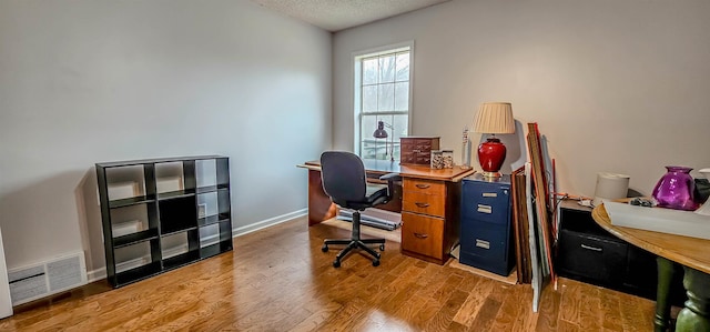office area with a textured ceiling and light hardwood / wood-style floors
