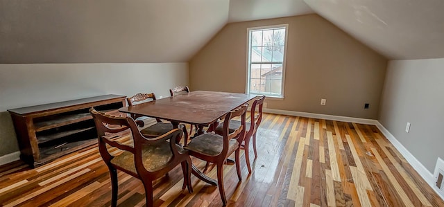dining space featuring lofted ceiling and light hardwood / wood-style flooring