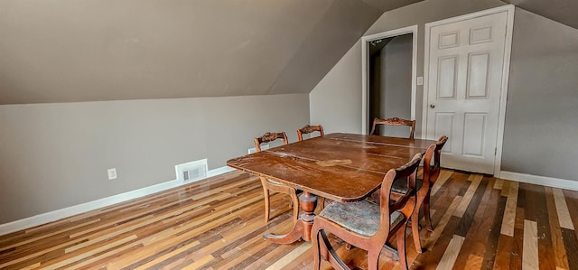 dining space with lofted ceiling and wood-type flooring