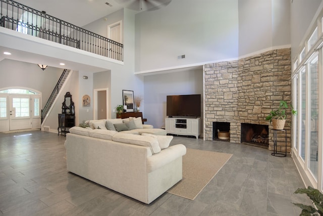 living room with a fireplace and a high ceiling