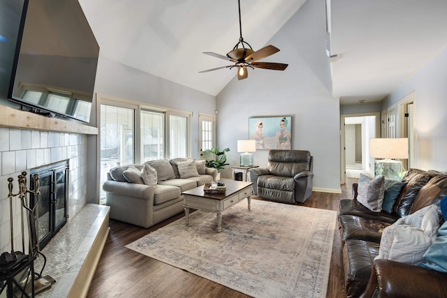 living room featuring ceiling fan, a fireplace, dark hardwood / wood-style floors, and high vaulted ceiling