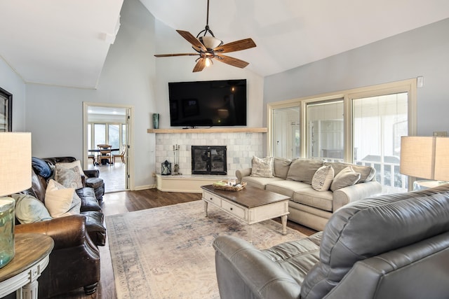 living room with dark hardwood / wood-style floors, ceiling fan, a fireplace, and high vaulted ceiling