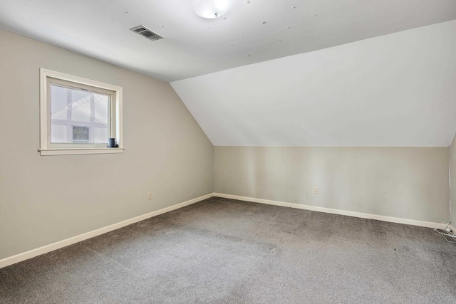 bonus room with vaulted ceiling and carpet floors