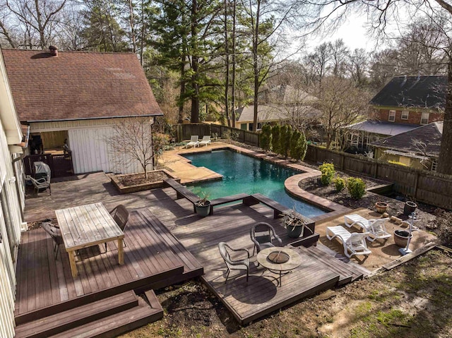 view of swimming pool featuring a wooden deck and a fire pit