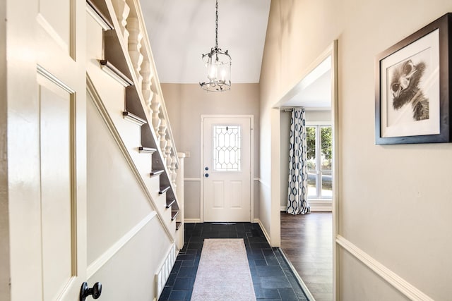 doorway to outside featuring lofted ceiling and a notable chandelier