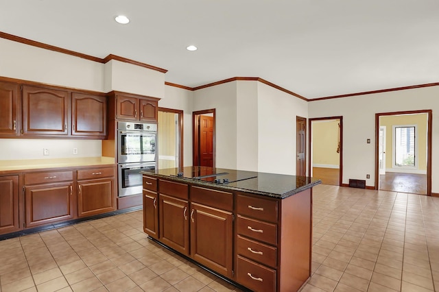 kitchen featuring crown molding, dark stone countertops, a center island, black electric stovetop, and stainless steel double oven