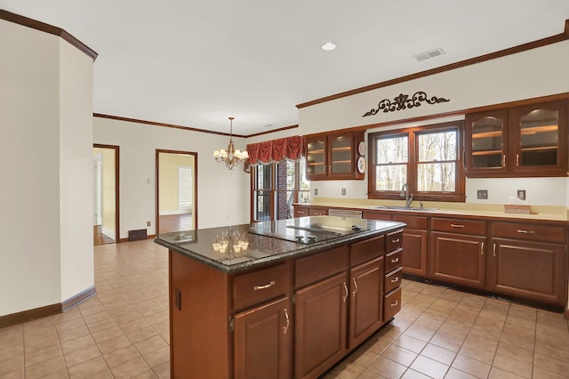 kitchen with black electric cooktop, sink, light tile patterned floors, and a center island