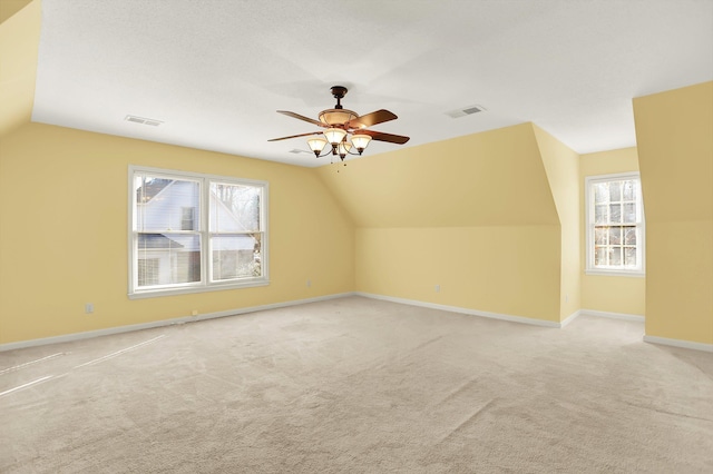 bonus room featuring vaulted ceiling, light carpet, and a wealth of natural light