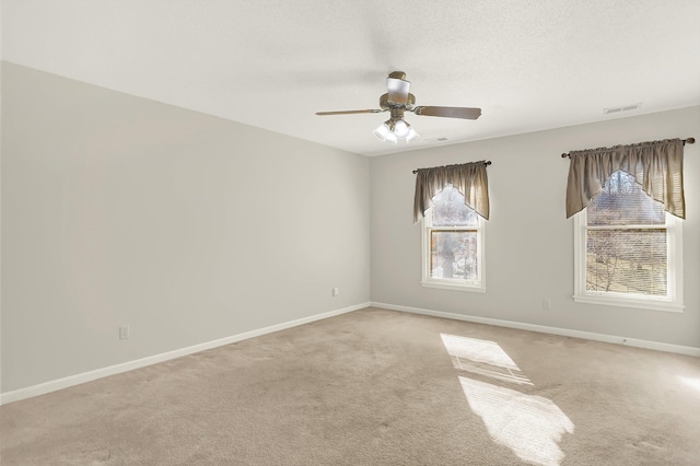 carpeted empty room with ceiling fan and a textured ceiling