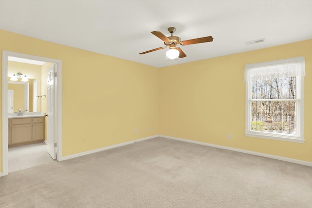 carpeted empty room featuring sink and ceiling fan