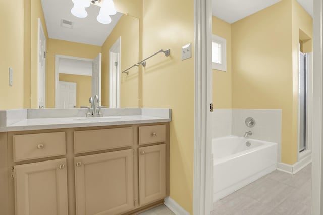 bathroom with vanity, a bathing tub, and a notable chandelier