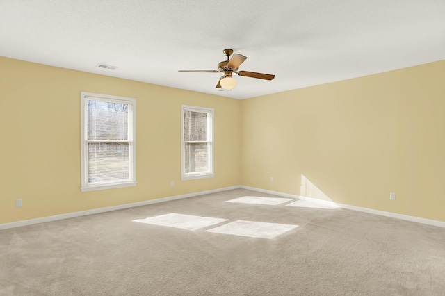 carpeted spare room featuring ceiling fan