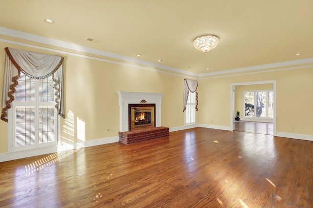 unfurnished living room featuring crown molding, a fireplace, and hardwood / wood-style floors