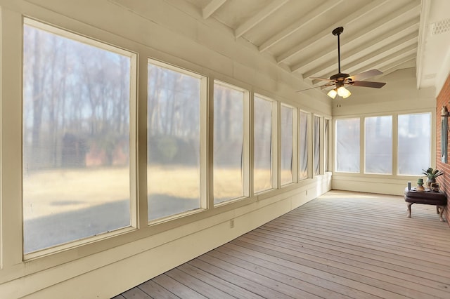 unfurnished sunroom featuring ceiling fan and vaulted ceiling with beams