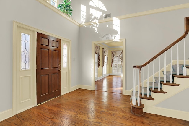 entrance foyer featuring a high ceiling, a healthy amount of sunlight, and hardwood / wood-style floors