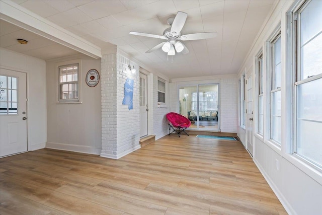 unfurnished sunroom featuring ceiling fan