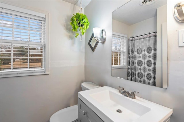 bathroom with vanity, toilet, and walk in shower