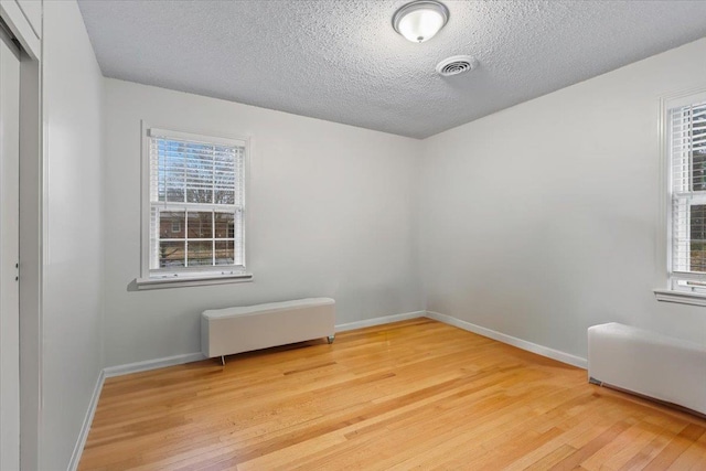 spare room with wood-type flooring and a textured ceiling