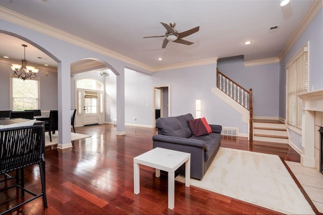 living room featuring a tiled fireplace, wood-type flooring, and ornamental molding