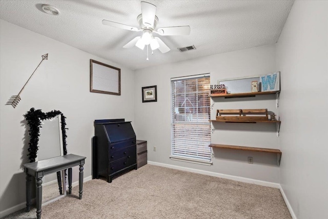 misc room featuring ceiling fan, light colored carpet, and a textured ceiling