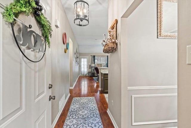 foyer entrance with dark hardwood / wood-style flooring and a notable chandelier