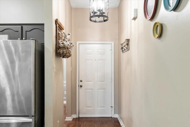 entryway with dark hardwood / wood-style floors and an inviting chandelier