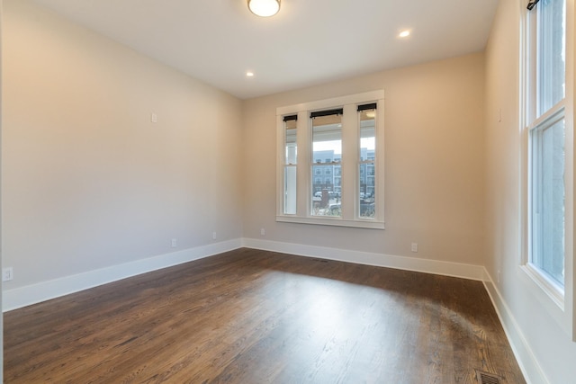 unfurnished room with dark hardwood / wood-style flooring