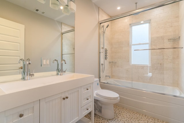 full bathroom featuring vanity, toilet, and combined bath / shower with glass door