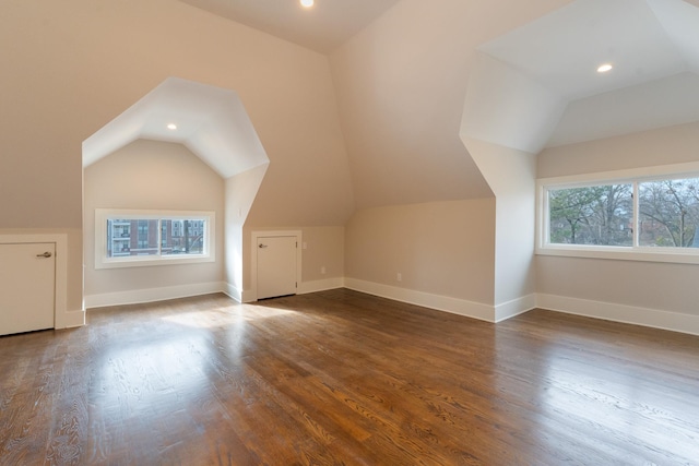 additional living space featuring lofted ceiling and dark hardwood / wood-style flooring