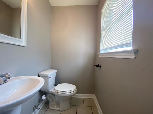 bathroom with toilet, tile patterned flooring, and sink