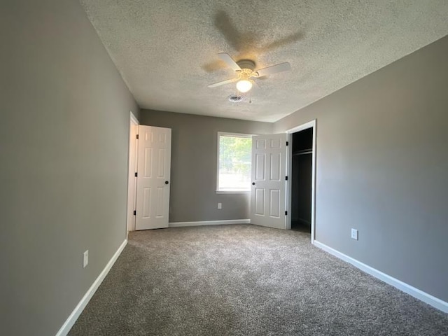 unfurnished bedroom featuring ceiling fan, a textured ceiling, and carpet