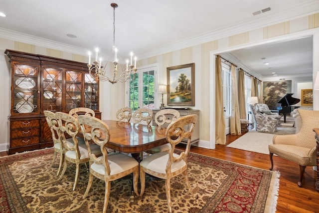 dining space with crown molding, dark wood-type flooring, and a chandelier