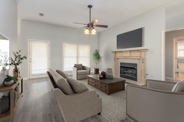 living room with ceiling fan, wood-type flooring, a fireplace, and plenty of natural light