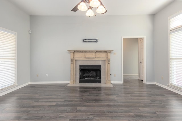 unfurnished living room featuring a fireplace, dark hardwood / wood-style floors, and ceiling fan