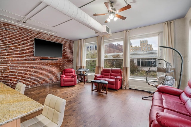 interior space featuring hardwood / wood-style flooring, brick wall, plenty of natural light, and ceiling fan