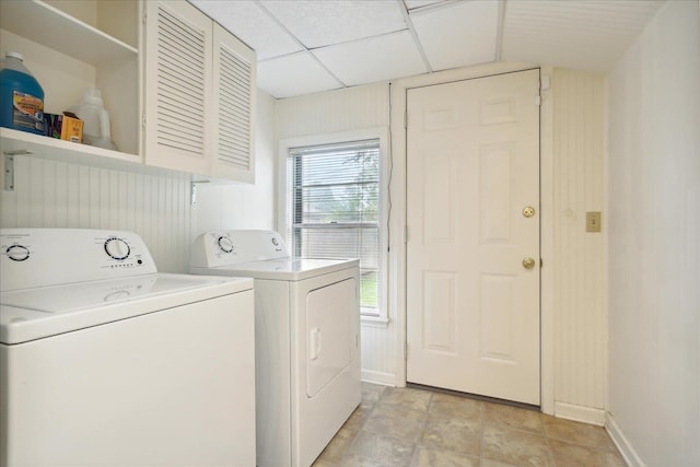 clothes washing area featuring cabinets and washing machine and dryer