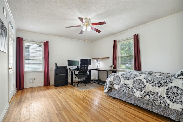 bedroom featuring multiple windows, ornamental molding, and light hardwood / wood-style flooring