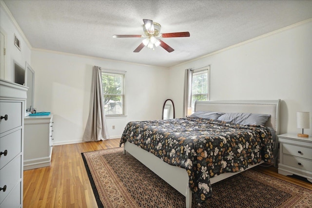 bedroom with ornamental molding, a textured ceiling, and light wood-type flooring