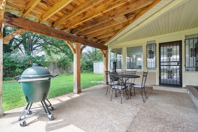 view of patio featuring a grill and a storage unit