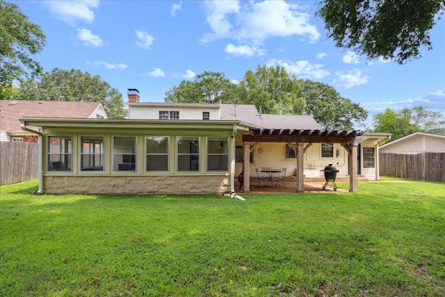 rear view of property featuring a pergola, a patio area, and a lawn