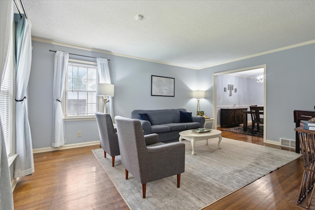 living room with hardwood / wood-style floors, crown molding, and a textured ceiling