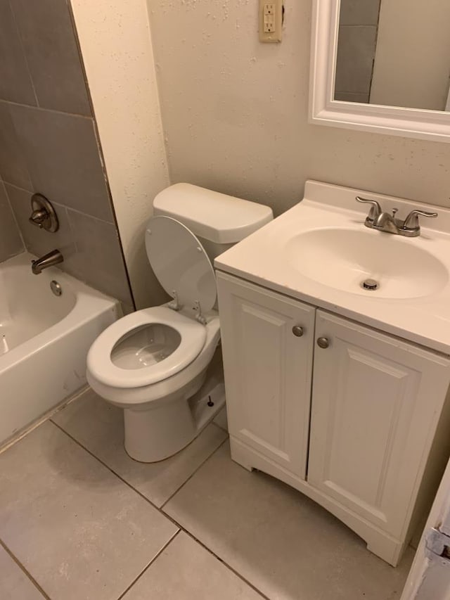 full bathroom featuring vanity, tiled shower / bath, tile patterned floors, and toilet