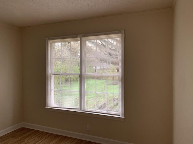 empty room with hardwood / wood-style flooring and a textured ceiling