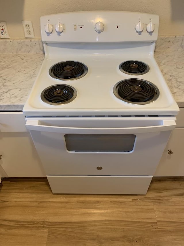 details featuring white range with electric cooktop, light hardwood / wood-style flooring, and white cabinets