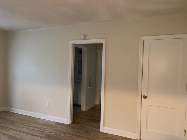 spare room with wood-type flooring and ornamental molding